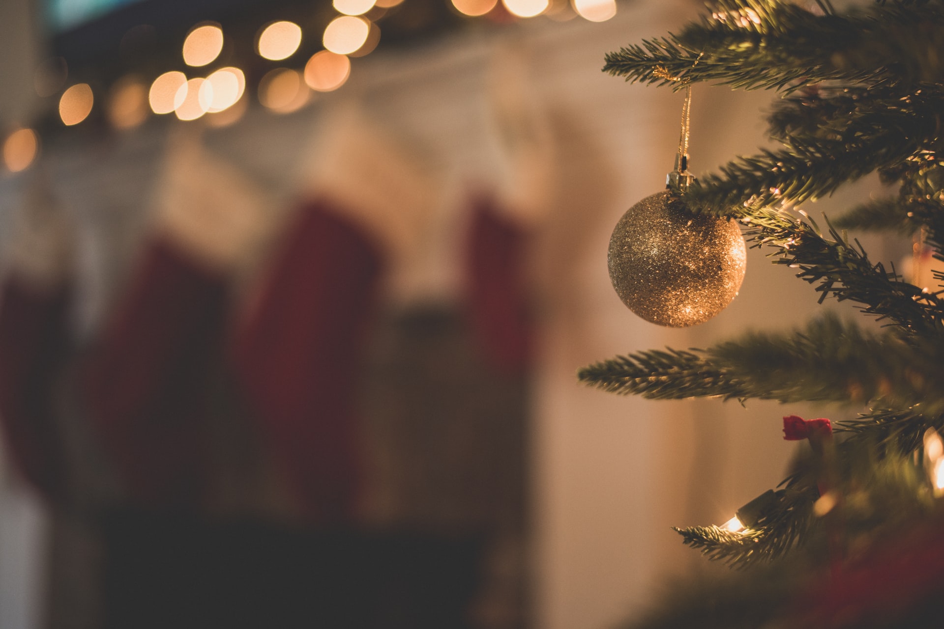 Softly blurred white Christmas lights, stockings, and Christmas tree